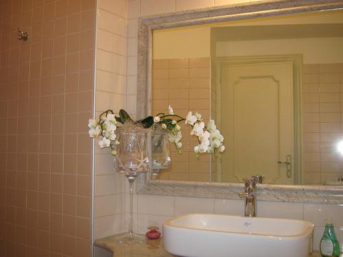 Colleretto GiacosaB&B Ristorante del Monte的浴室设有水槽、镜子和花瓶