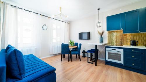 耶莱尼亚古拉HELLO Apartamenty Evo - Długa 15的一间带蓝色沙发的客厅和一间厨房