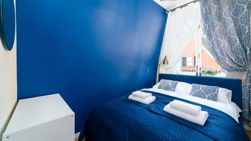 耶莱尼亚古拉HELLO Apartamenty Evo - Długa 15的蓝色卧室配有蓝色的床和白色枕头