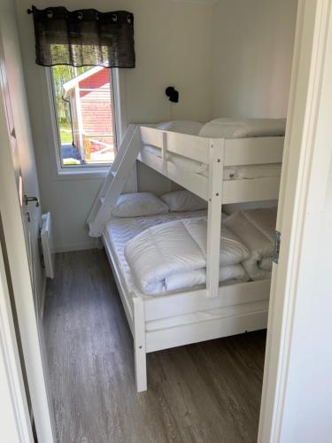 HammarHarge Bad & Camping的客房内的双层床,配有白色双层床