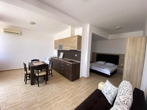帕莫瑞Sunrise Apartments, Pomorie的客厅配有沙发、桌子和床。