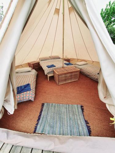 利马瓦迪Swanns Bridge Glamping的一个带柳条椅和地毯的帐篷