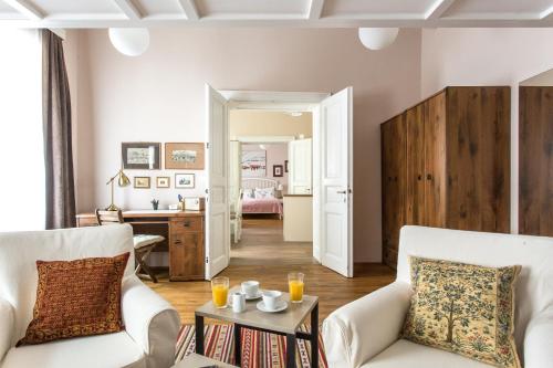 卢布尔雅那Rohrmann apartments的客厅配有2把白色椅子和桌子