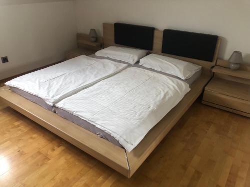 克拉根福Klagenfurt`s Loft的卧室配有一张带白色床单和枕头的大床。