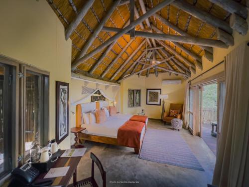 奥考奎约Ongava Lodge的一间卧室配有一张床和一张书桌