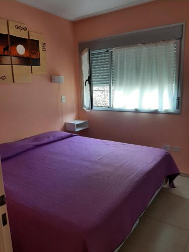 布兰卡港Departamento de la Bahia的一间卧室设有紫色的床和窗户