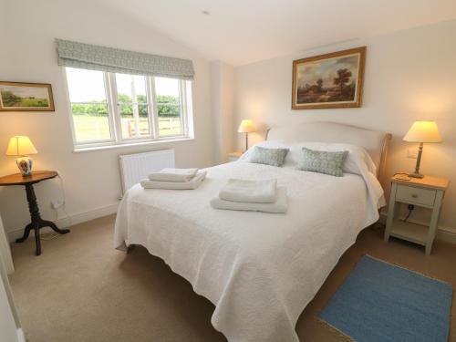 切尔滕纳姆Flagstone Cottage的卧室配有带毛巾的大型白色床