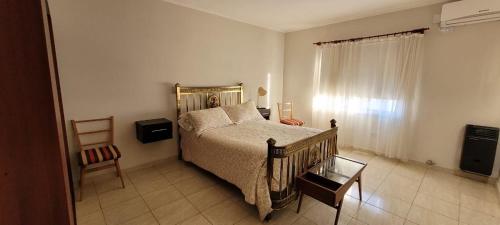 纳瓦罗Navarro Departamentos Temporarios的卧室配有1张床、1张桌子和1把椅子