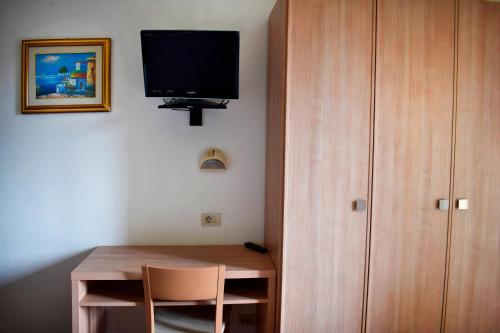 切塞纳蒂科Hotel Gattuccio的客房设有书桌和墙上的电视