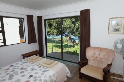 普利登堡湾Imperani的卧室配有床、椅子和窗户。