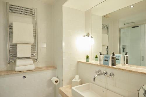 哈斯尔米尔The Georgian, Haslemere, Surrey的白色的浴室设有水槽和镜子