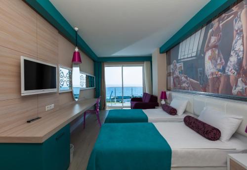 基兹洛特苏丹Spa梦酒店 的客房设有两张床和一张书桌及一台电视。