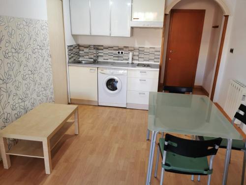 加的斯Apartamento Playa Victoria的厨房配有桌子和洗衣机。