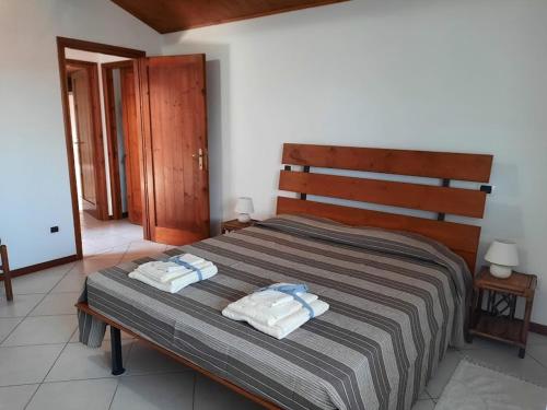 奥里斯塔诺CASA CATY - Oristano的一间卧室配有一张床,上面有两条毛巾