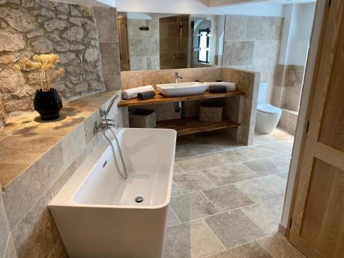 TréjoulsLe Relais de Campagne的浴室配有白色浴缸和水槽