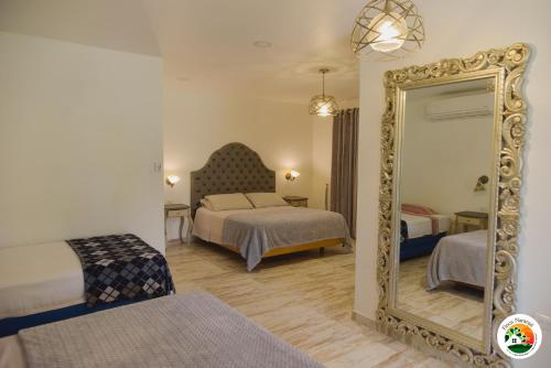 格拉纳达Hotel Finca Naranjal的酒店客房,设有两张床和镜子
