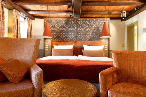 罗滕堡浪漫马库斯图姆酒店的一间卧室配有一张床和两把椅子