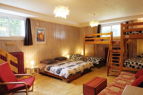 奥特朗Gîte SOLDANELLE - 15 personnes - "Les Gites du Chalet" à Autrans的一间卧室配有一张床和两张双层床。