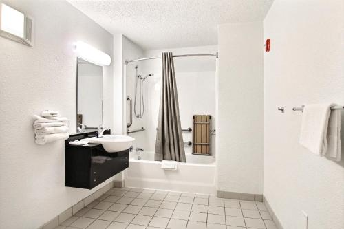 米德尔堡海茨克利夫兰-米德尔堡6号汽车旅馆的白色的浴室设有水槽和淋浴。