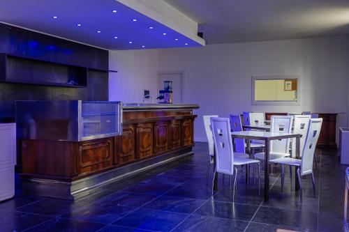 加拉瑞特Pasta Residence Italia Malpensa的一间带桌子和白色椅子的用餐室