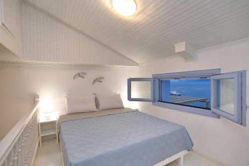 斯科派洛斯Skopelos Aerino house的一间卧室设有一张床和一个窗口