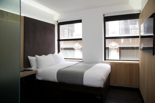 伦敦皮卡迪利Z酒店的一间卧室设有一张床和两个窗户。