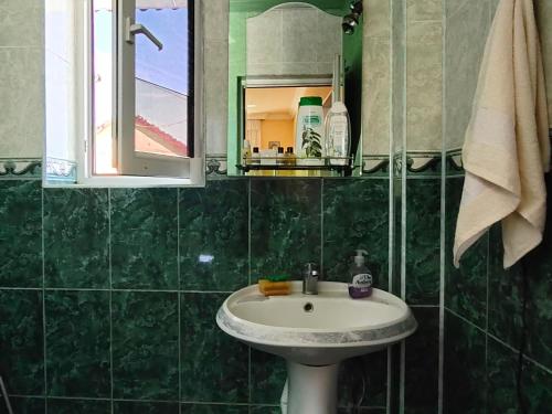 库巴La Casa de Habel的绿色瓷砖浴室设有水槽和镜子
