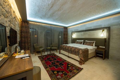 乌奇希萨尔Ahiyan Hotel的一间酒店客房,一间设有一张床和一张书桌