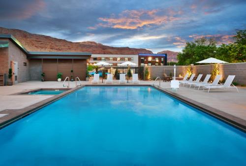 摩押Gravity Haus Moab的一个带椅子的大型游泳池和一间酒店