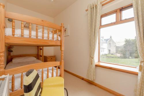 MayboleFoxglove Cottage的一间卧室配有双层床和窗户。