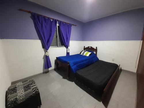 圣达菲Tomay Apart的一间卧室设有一张床和一个带紫色墙壁的窗户。