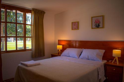伊察Casa Solaris的一间卧室配有一张带两盏灯的床和一扇窗户。