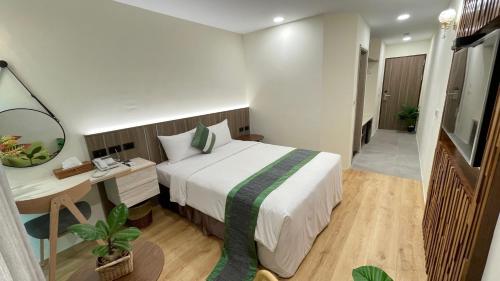 垦丁大街海的墾丁旅店 Ocean KT Inn的一间卧室配有一张床和一张带镜子的书桌