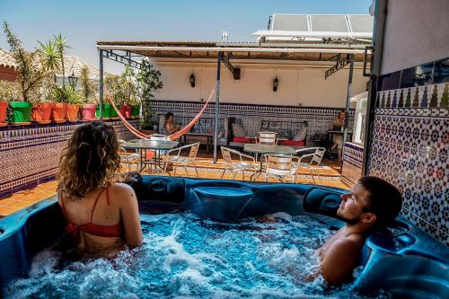 塞维利亚Hostel Triana Backpackers的热水浴池中的男女