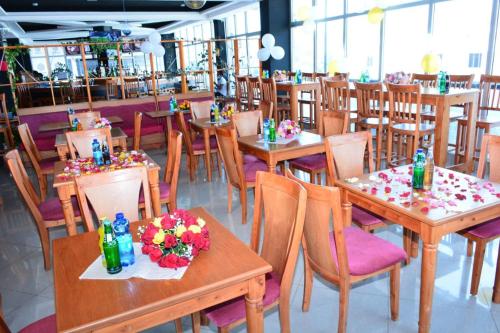 亚的斯亚贝巴bruhway hotel的餐厅设有木桌和鲜花椅子