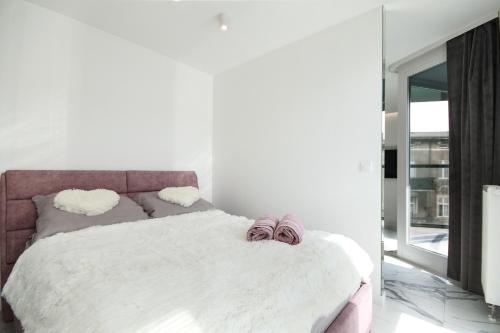 波兹南Apartamenty HashtagWilda_Apartament Złoty的一间卧室配有一张带白色床单和镜子的床