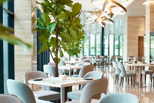 新山Opero Hotel Southkey Johor Bahru的一间配备有桌椅的用餐室和植物