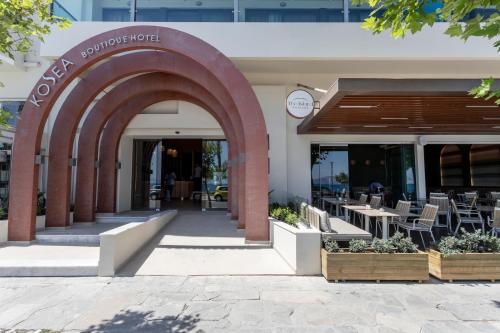 科斯镇KoSea Boutique Hotel的拱门通往带桌椅的餐厅