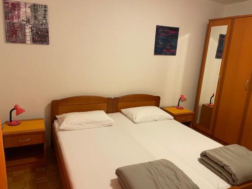 科尔丘拉Ivana Apartment的一间卧室配有一张带两盏灯的大型白色床。
