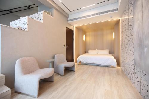 花莲市椛堤VILLA的一间卧室配有一张床和两把椅子