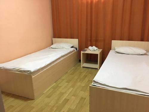 卡拉甘达Гостиница"Hostel"的一间设有两张床和床头柜的房间