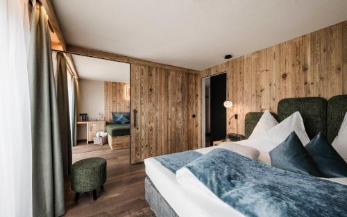 阿尔卑斯休斯山金诺普酒店的一间卧室设有一张床和木墙