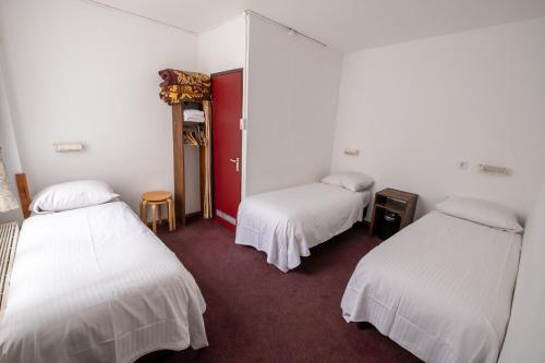 阿姆斯特丹本中心酒店的一间设有两张床和红色门的房间