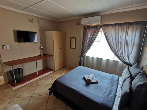 赫卢赫卢韦Hluzu Guest House的一间卧室配有一张带横跨床的卧室