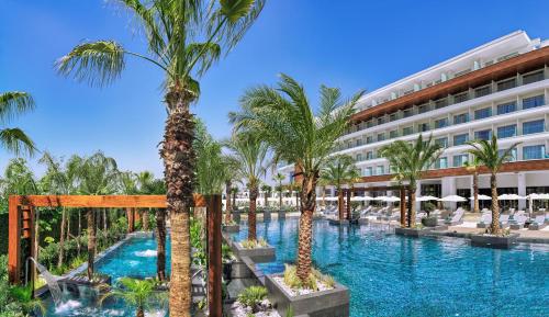阿依纳帕Amanti, MadeForTwo Hotels - Ayia Napa的棕榈树和建筑的度假游泳池