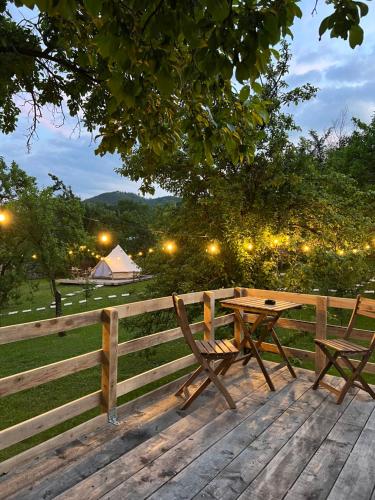 BozioruTinutul Luanei Glamping Resort的围栏旁的木桌和长凳