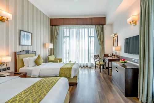 尼泊尔根杰Soaltee Westend Premier的酒店客房设有两张床和电视。
