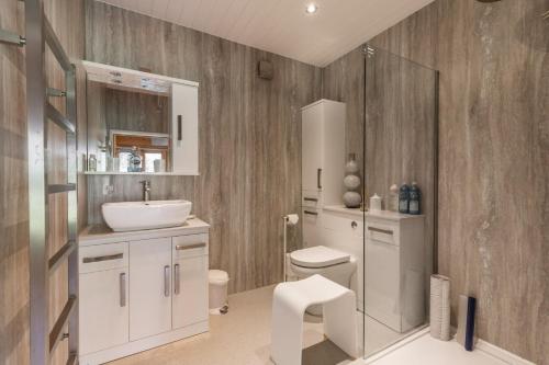NeatisheadViolet Lodge - Norfolk Holiday Properties的浴室配有白色水槽和卫生间。