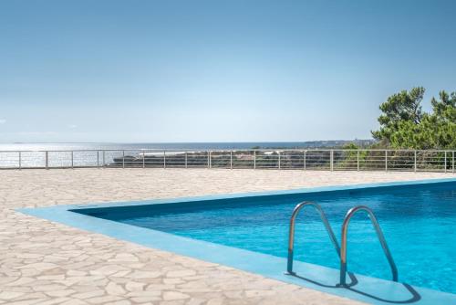 费马波尔特贝利撒留酒店的海滩上的游泳池,背景是大海