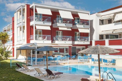 波利克罗诺夏日之梦酒店的一座设有游泳池、椅子和遮阳伞的酒店
